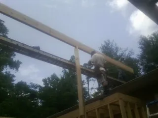 Carpenter setting a ridge beam over a new addition frame — Ice Dam Removal by Roofing Brothers in Southbury
