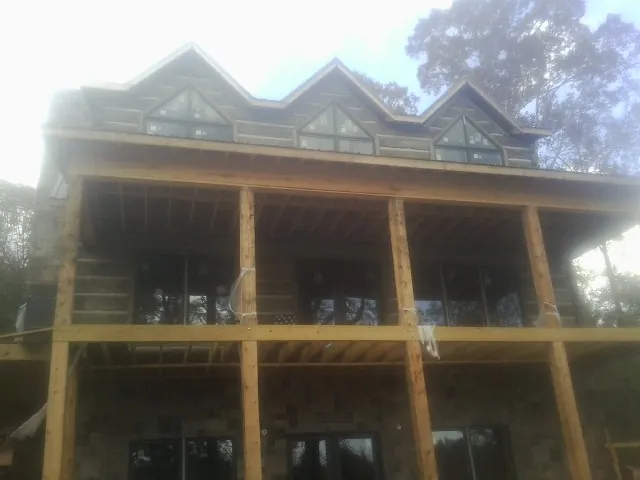 Dormers and porch framing on a large log home under construction — Roof Coating work by our crew in Southbury