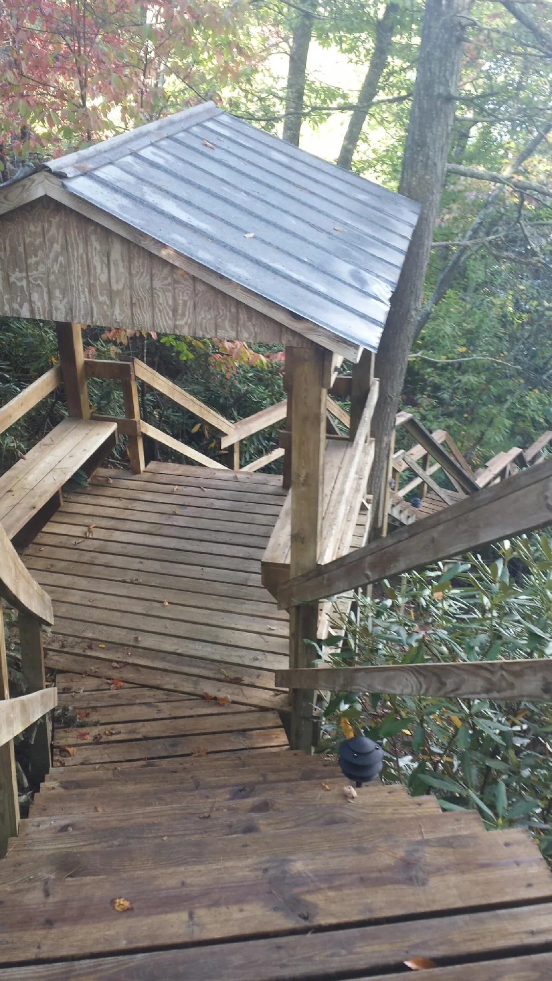 Metal roofed shelter over wooden steps on a wooded walkway — Skylight Repair & Installation work by our crew in Southbury